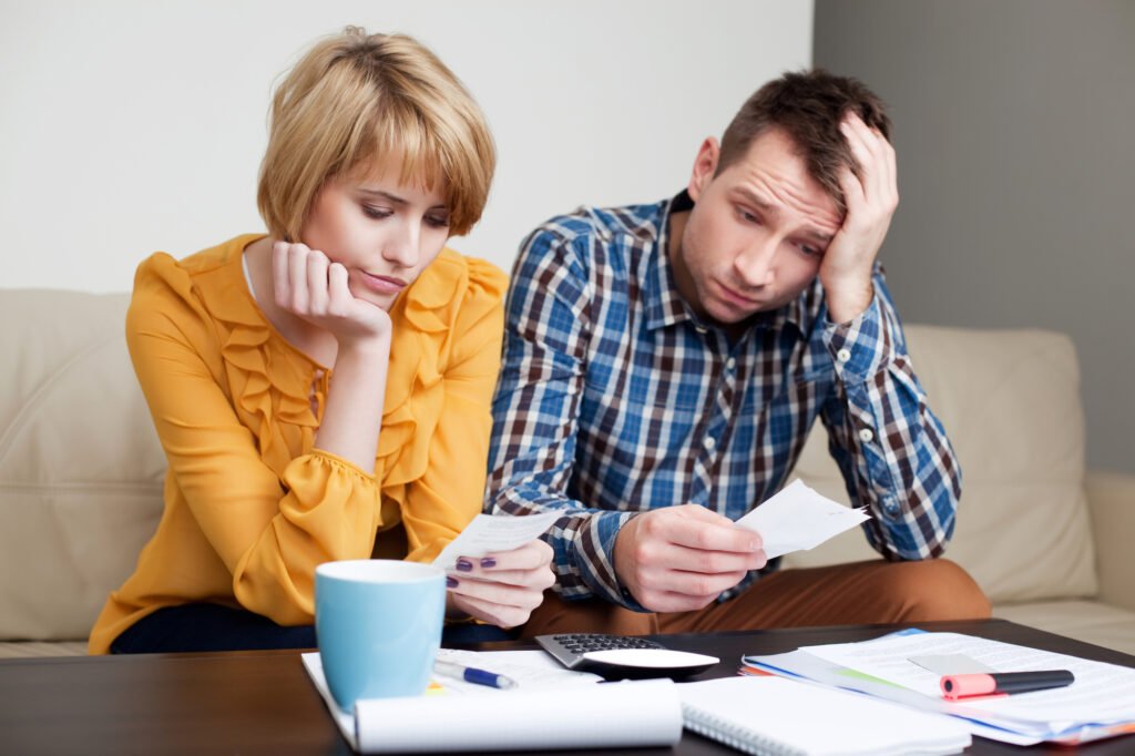 Couple reviewing bills to understand the New York foreclosure process